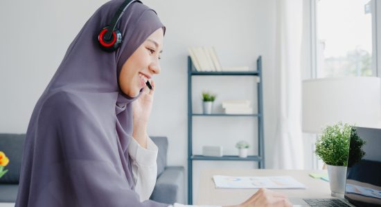 Asia muslim lady wear headphone watch webinar listen online course communicate by conference video call at house. Remotely working from home, social distancing, quarantine for corona virus prevention.